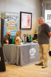 Trade show booth with three people interacting.