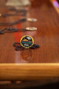 Logging badge on wooden table with chain.