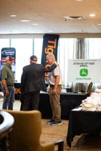 Three men talking at a business event.