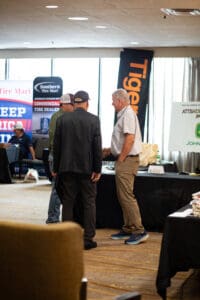 Three men talking at indoor trade show