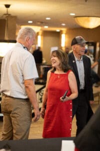 Three people conversing at an indoor event.