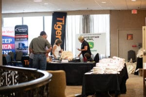 People browsing tables at a trade show.