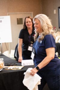 Two women at a conference registration table.