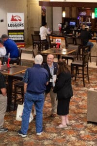 People conversing at logging industry event.