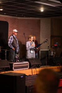 People speaking on stage with microphones.