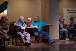 Men conversing at a table indoors.