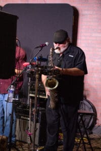Musician playing saxophone on stage performance.