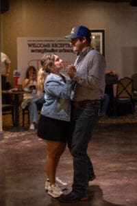 Couple dancing together at indoor event.