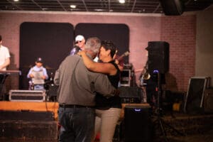 Couple dancing at live music venue.