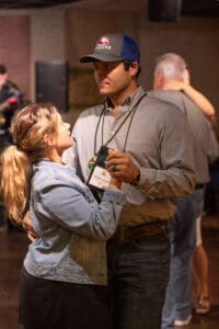 Couple dancing in casual attire at event.