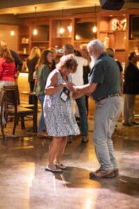 Elderly couple dancing in a lively bar.