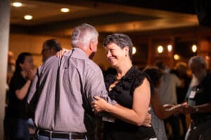 Couple dancing happily in a dimly lit room.