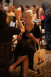 Woman sitting and talking in crowded room.