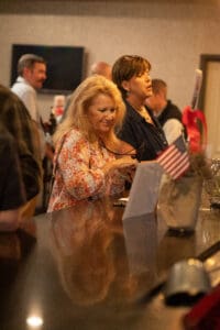 Women at a bar with American flag.