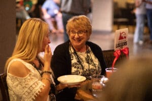 Two women chatting over drinks at table