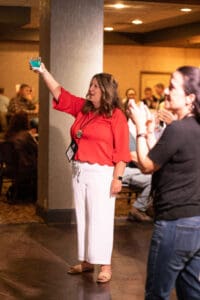 Woman in red top raising a drink.