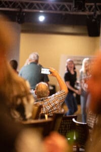 Person taking photo of people on stage.