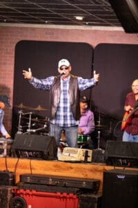 Singer performing on stage with band.