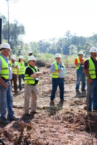 Workers in safety gear at construction site.