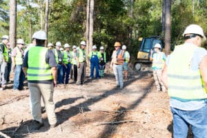 Construction crew safety briefing near excavator
