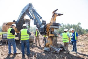 Workers examining machinery at construction site.