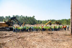 Construction workers gathered at a deforested site.