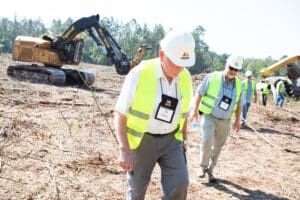 Construction workers walking on a cleared site.