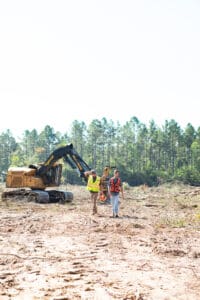 Two workers in a forest clearing site.