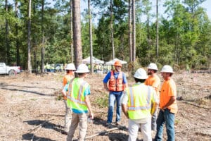 Construction workers discussing in a forest area.
