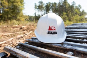 White hard hat on logging equipment outdoors.
