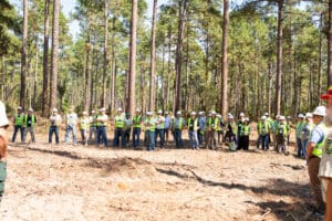 Group of people in forest with helmets.
