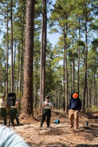 People working in a forest clearing.
