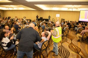 Large group attending a conference in ballroom.