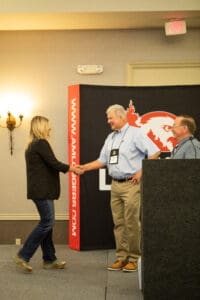 People shaking hands at a conference event.