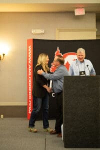 Three people on stage at a conference.