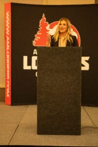 Woman speaking at a conference podium.