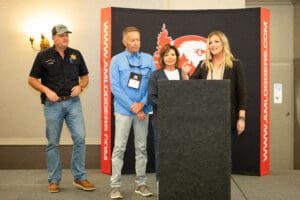 Four people standing at a podium event.