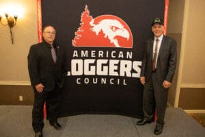 Two men standing by American Loggers Council backdrop.