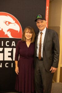 Man and woman smiling at an event.