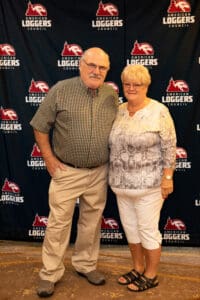 Elderly couple smiling at a loggers' event.