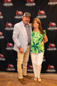 Couple posing at American Loggers Council backdrop