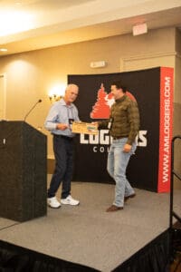 Two men exchanging an award on stage.