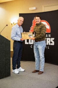 Two men at an award ceremony stage.
