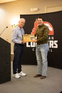 Two men holding an award on stage.