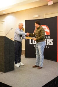 Two men shaking hands at awards ceremony