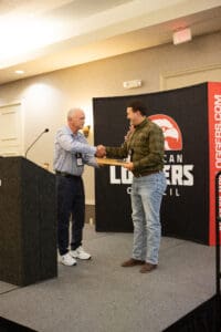 Two men shaking hands on stage