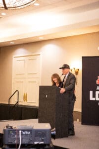 Man and woman speaking at a podium.