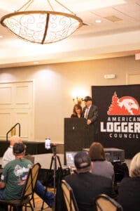 Speakers at American Logger Council event podium.