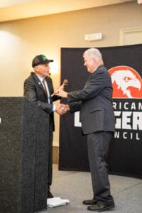 Two men shaking hands at podium.