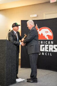 Two men exchanging gavel on stage